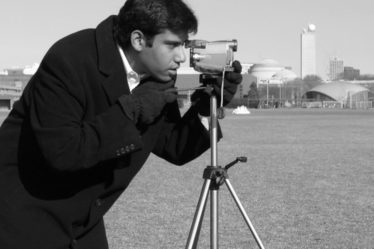 A photographer using a camera on a tripod